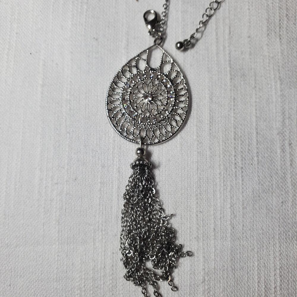 silver-tone pendant necklace features an ornate filigree medallion and a...